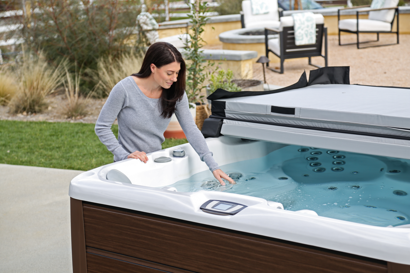 Lady checking the water on a Sundance Spa