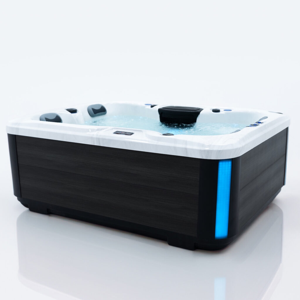 A wide angle of the dark wood effect outer shell of the Core spa with the external lighting strip illuminated blue.