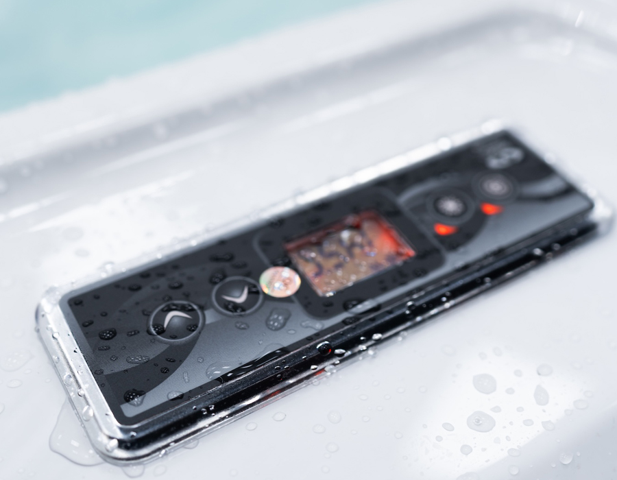 Close-up of a Gecko control panel with water droplets. The digital display shows "55". Black buttons with red lights give a modern, sleek look.