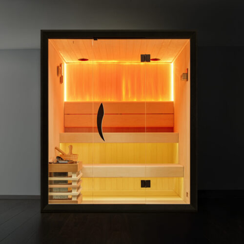 Modern sauna in dimly lit room. Warm, orange glow emanates from wooden interior, creating a relaxing, inviting atmosphere. Glass door with sleek handle.