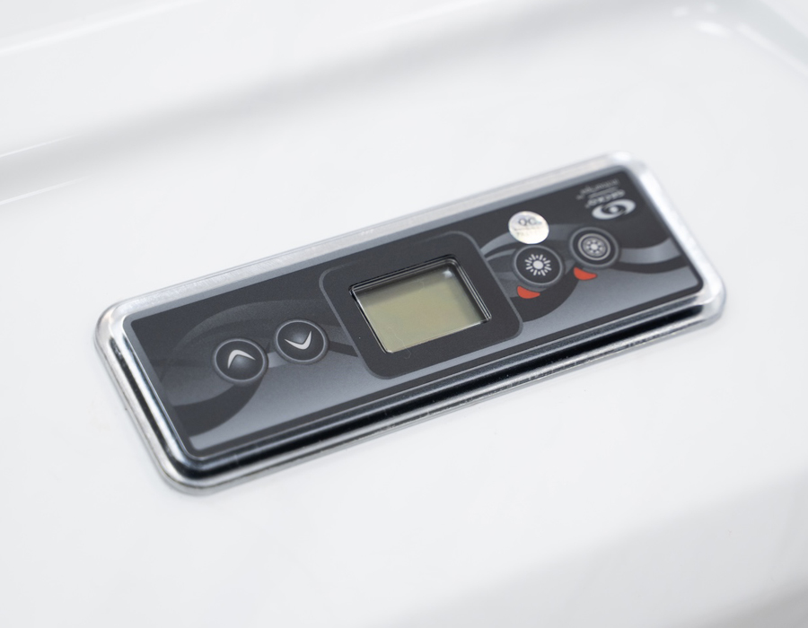 Close-up of a sleek Gecko control panel on a white acrylic hot tub shell.