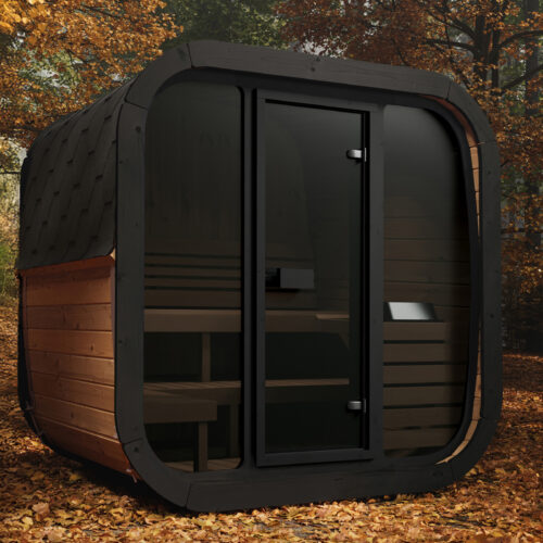 Modern wooden sauna cabin with a glass door, nestled in a forest with vibrant autumn leaves on the ground, evokes warmth and tranquility.